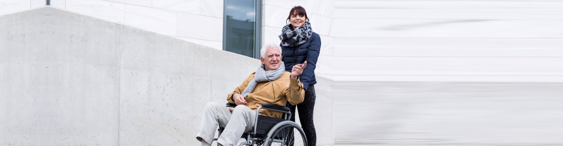 woman assisting old man in wheelchair