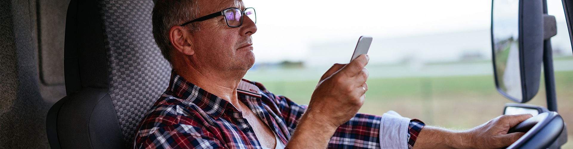 man browsing his phone while driving